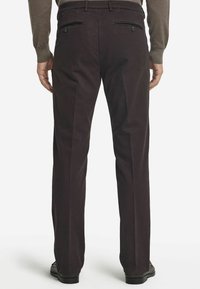 Mörkbruna byxor tillverkade av en bomullsmix. Har två bakfickor med knappstängningar, sidofickor och rak bendesign.