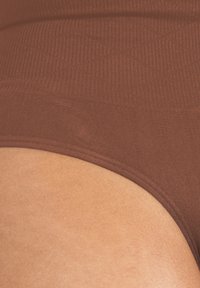 Bruine high-waisted onderbroek gemaakt van gladde, rekbare stof met een geribde tailleband en naadloze voegen voor comfort.