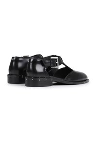 Schwarze Lederstiefel mit einem Ausschnitt-Design, einem Knöchelriemen mit einer silbernen Schnalle und Nietenverzierungen an der Ferse.
