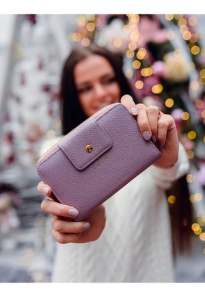 Purple leather wallet featuring a textured surface, gold hardware button, and a flap closure. Brand name “VUCH” embossed on the front.