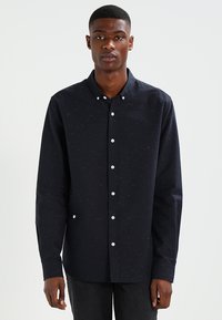 Camicia button-up blu scuro con un motivo a macchie, realizzata in un tessuto strutturato. Caratterizzata da un colletto classico e maniche lunghe.