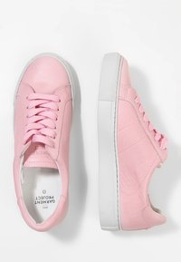 Růžové kožené tenisky s kulatou špičkou, plochou bílou podrážkou a odpovídajícími tkaničkami; obsahují jemné švy a texturovaný povrch.