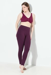 Sostenedor inalámbrico burdeos con un diseño de frente fruncido, combinado con leggings de cintura alta a juego en una tela suave y elástica.