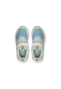 Light blue and white athletic shoes featuring mesh material, a padded collar, adjustable strap, and green accents on the heel and sole.