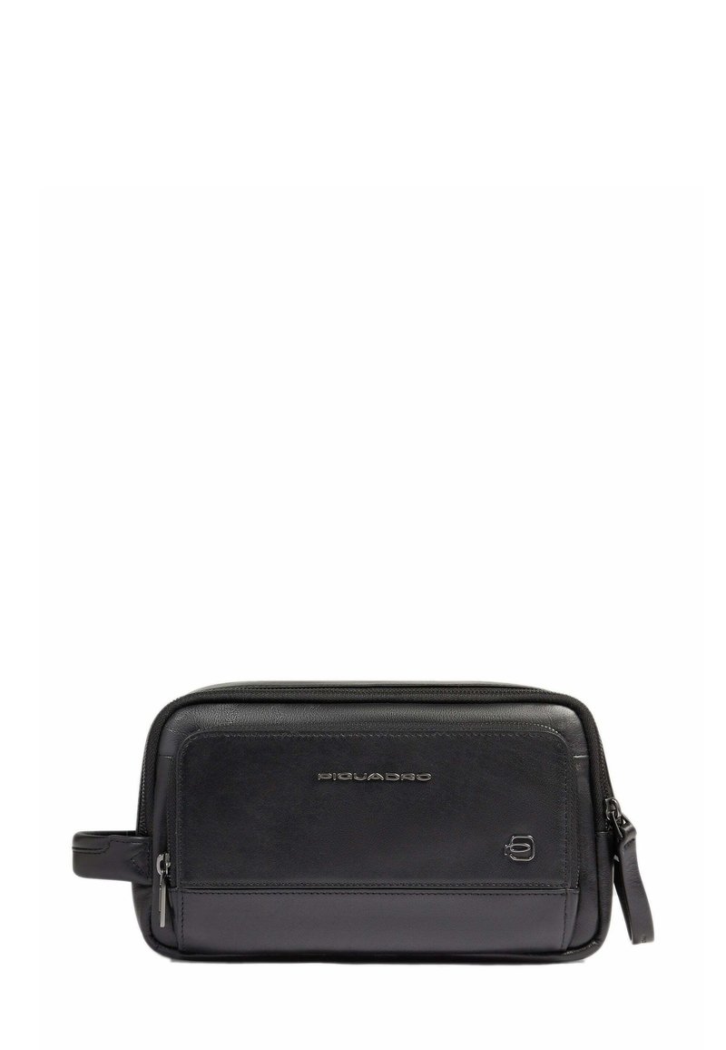 Pochette da viaggio in pelle nera con forma rettangolare, texture liscia, chiusura con zip e manico laterale. Presenta un branding sottile sulla parte anteriore.