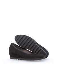 Chaussures à talons compensés en suede noir avec un bout arrondi, semelle en caoutchouc plat dotée de rainures horizontales et un design à enfiler. Doublure intérieure lisse.