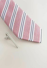 Cravate rayée rose avec des rayures blanches et marine, accompagnée d'une pince à cravate en argent avec un bord texturé et un design rectangulaire épuré.