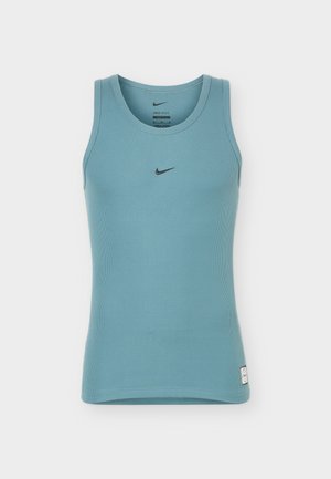 Débardeur côtelé bleu Nike sans manches avec un col rond et un petit logo swoosh noir au centre de la poitrine.