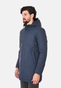 Giacca impermeabile blu navale con cappuccio, zip frontale e tasche laterali. Tessuto liscio e design di lunghezza media.