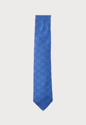 Cravate bleue avec un motif répété de lettres entrelacées bleu foncé et de formes d'étoiles sur un fond clair.