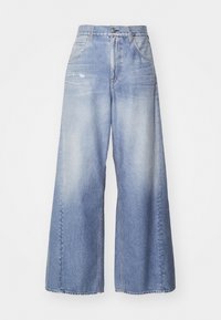 Široke jeans hlače iz denima v svetlo modri barvi, z izblukano prho, petimi žepi in gumbnim zapiranjem. Tekstura tkanine je gladka z vsakdanjim videzom.