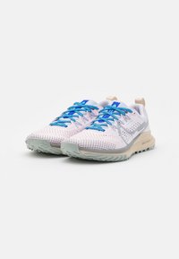 Scarpe da corsa leggere in rosa e grigio con tomaia in mesh, lacci blu e suola testurizzata progettata per aderenza e stabilità.