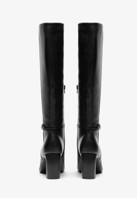 Black knee-high boots made of smooth leather with a block heel, featuring side zippers and a buckle accent near the ankle.