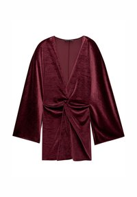 Haut cache-cœur en velours bordeaux avec un décolleté en V profond, des manches larges et un détail torsadé à l'avant. Texture lisse avec une légère brillance.