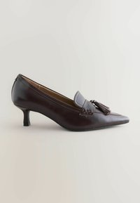 Brauner Lederhohe Schuh mit spitzer Zehe, dekorativem Quast und niedrigem Blockabsatz. Glatte Textur mit subtilen Nähdetails.