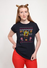 Camiseta azul marino con un diseño pixelado de SpongeBob, con medusas rosas y patrones divertidos. Manga corta y escote redondo.