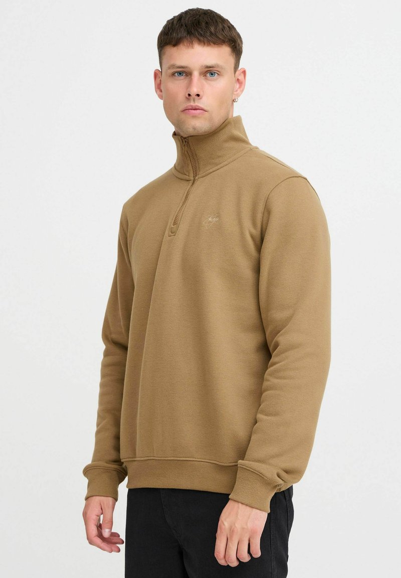 Brown, mid-length zip sweatshirt in soft fabric with ribbed collar and cuffs. Features a discreet logo on the left chest.