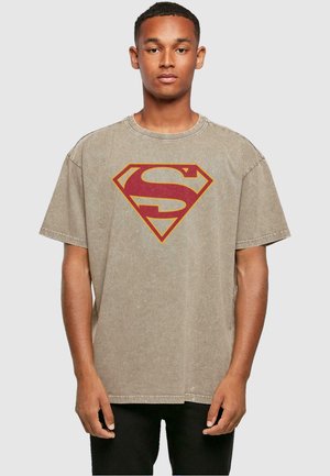 Beige kortærmet bomulds t-shirt med et stort rødt og gult Superman-logo på fronten, med en afslappet pasform og rå kantdetaljer.