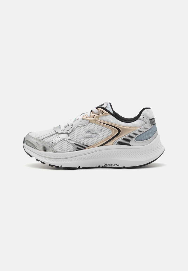 Chaussure de sport blanche et argentée avec des accents dorés, tige en maille, col rembourré, fermeture à lacets et semelle texturée. Présente des lignes de design élégantes.