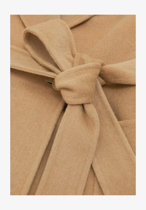 Beiger Filzstoff mit einem gebundenen Taillendetail und einem Knopfverschluss. Die Textur ist weich, und das Design verfügt über einen offenen Kragen und symmetrische Falten.