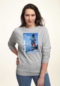 Felpa grigia con un design grafico blu, testo "SINCE 1981" e immagini di montagne. Collo e polsini a costine, vestibilità rilassata.