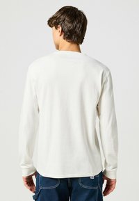 Koszula z długim rękawem w off-white z bawełny, z prążkowanymi mankietami i okrągłym dekoltem, z prostym dołem i bez widocznych wzorów czy logo.