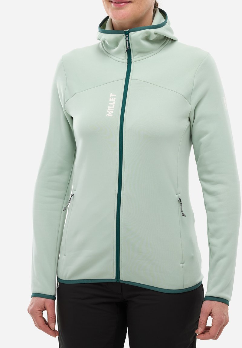 Veste softshell vert menthe avec fermeture éclair, col montant, poches latérales et accents contrastants vert foncé le long de la fermeture éclair et de l'ourlet.