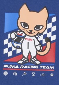 Tegneserie kattefigur i et racertøj, der holder en hjelm. Funktioner med blå baggrund med ternede mønstre og røde accenter. Tekst "PUMA RACING TEAM."