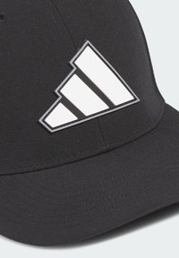 Sort cap lavet af stof med et fremtrædende hvidt tre-stribe logo design. Buet skygge og syet detaljer.