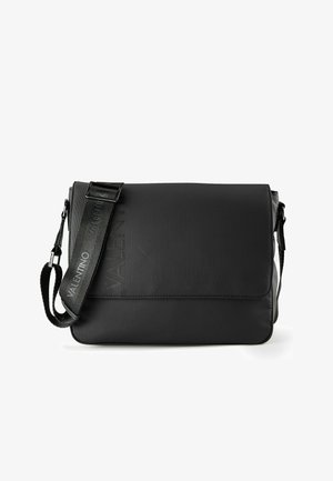 Black messenger bag made of textured nylon. Features a flap closure, adjustable strap, and embossed "VALENTINO" logo on front.