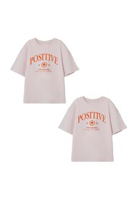 Rosa Baumwoll-T-Shirt mit kurzen Ärmeln, das orangefarbene "POSITIVE"-Schriftzug und ein Grafikdesign zeigt. Casual-Schnitt mit Rundhalsausschnitt.