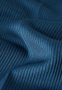 Gestructureerde, ribbelige stof in donkerblauw, met een gladde afwerking en duidelijke verticale lijnen. Zacht materiaal met een golvende val.