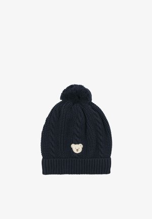 Gorro de punto azul marino con patrones de trenzas, un pompón en la parte superior y un pequeño parche frontal con la cara de un osito blanco.