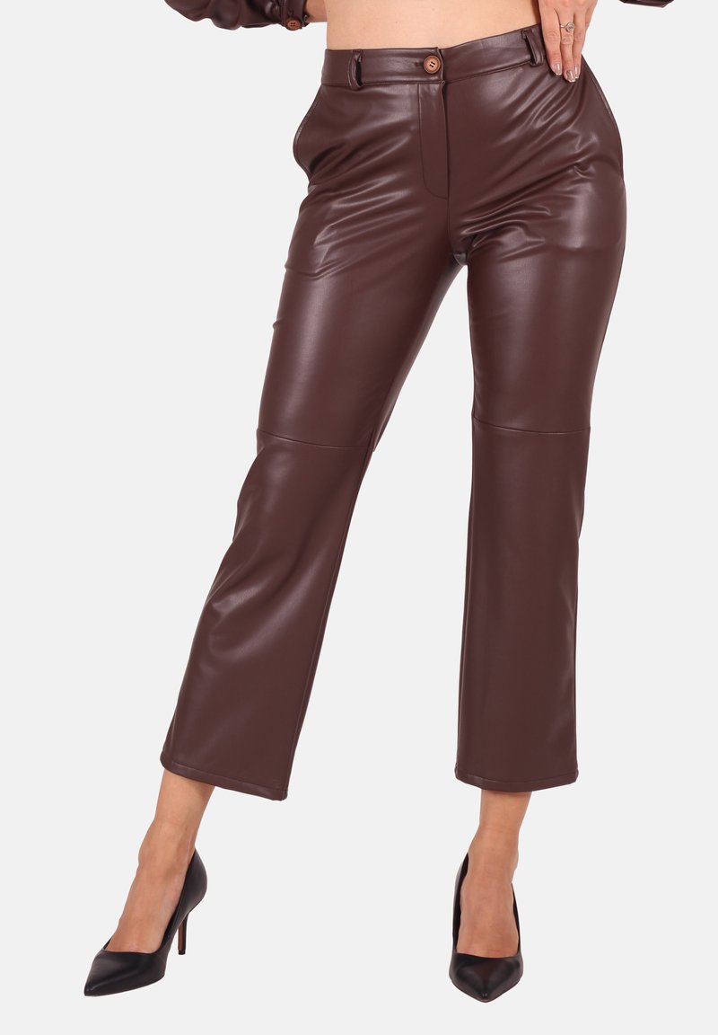 Braune Kunstlederhosen im Slim-Fit-Stil, mit einem Knopfverschluss, zwei Fronttaschen und einer verkürzten Länge. Glatte Textur und elegantes Design.