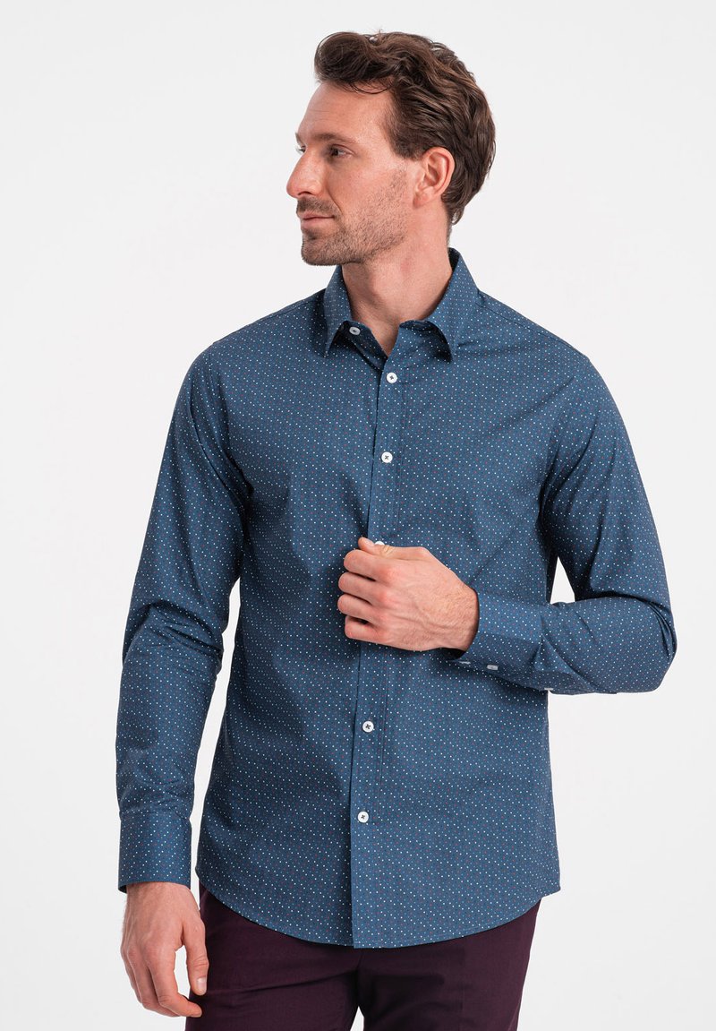 Camicia blu navy con piccoli pois multicolori, realizzata in tessuto intrecciato. Presenta un colletto classico e maniche lunghe.