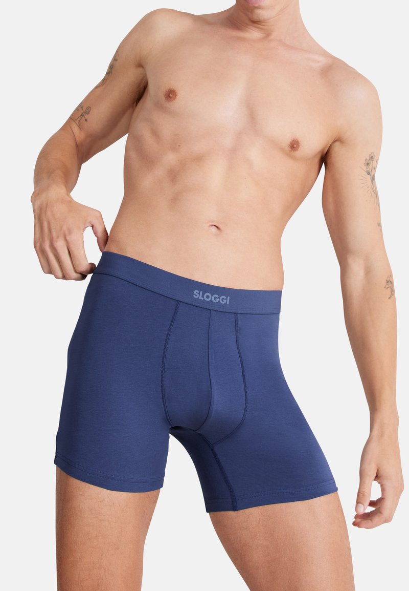 Granatowe bokserki SLOGGI o gładkiej strukturze, elastycznym pasie i kontrastującym ściegu; zaprojektowane z myślą o komforcie i dopasowaniu.
