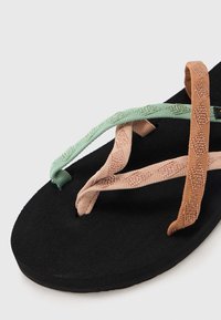 Black sandal with three braided straps in mint green, pink, and tan. The sole features a smooth, matte texture.