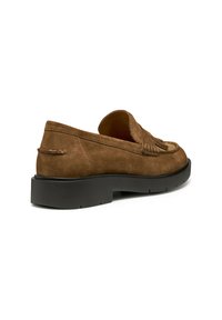 Scarpa slip-on in camoscio marrone con dettaglio a frange e suola nera spessa, vista da dietro, che mette in evidenza la texture e gli elementi di design.
