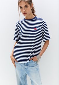 Marineblå og hvid stribet bomulds T-shirt med korte ærmer og rund halsudskæring, med et "Sweet Dessert" design med kirsebær.