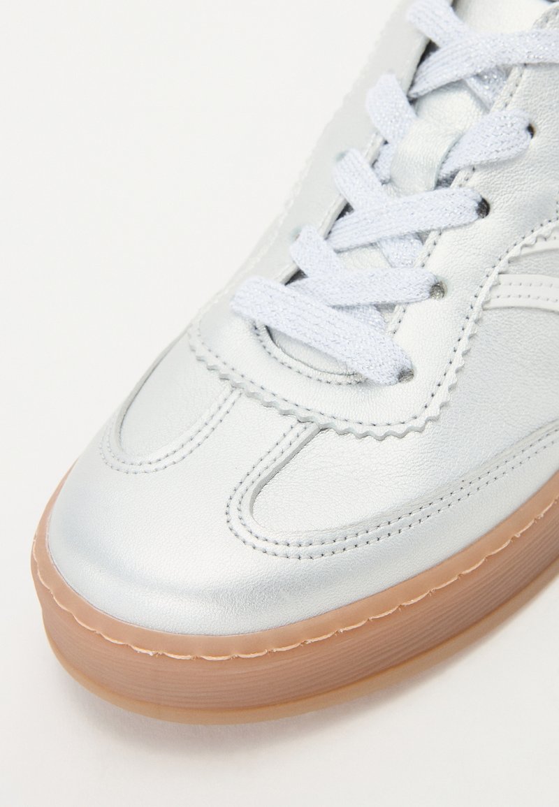 Silberne Leder-Sneaker mit tonal abgesteppten Nähten, flachen Schnürsenkeln und einer braunen Gummisohle. Verfügt über ein klassisches Design und eine gewellte Kantenverzierung.
