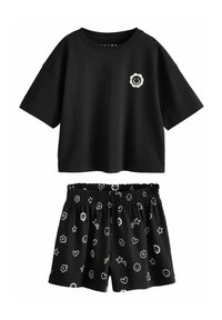 Fekete pamut póló kerek nyakkivágással és virágos smiley grafikával. Fekete rövidnadrág elasztikus derékpánttal, különféle fehér játékos motívumokkal díszítve.