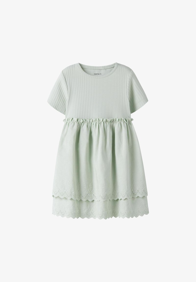 Robe vert clair à manches courtes avec corsage côtelé, taille froncée et ourlet double couche festonné avec détails de broderie.