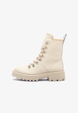 Kremowe skórzane buty za kostkę wiązane z teksturowanym wykończeniem, wyściełanym kołnierzem oraz masywną gumową podeszwą. Posiadają metalowe haczyki oraz kontrastowe przeszycia.