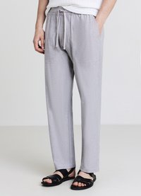 Hellgraue, entspannt geschnittene Hose mit elastischem Bund und verstellbarem Kordelzug. Verfügt über zwei Seitentaschen und ein glattes, weiches Material.