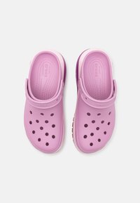 Pink rubber clogs with circular ventilation holes, a back strap for support, and textured insoles for comfort. Features a white outer sole.
