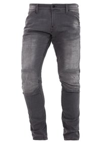 Jeans de denim gris ajustados con áreas desgastadas, detalles rasgados, paneles en las rodillas, cierre de botón y cremallera, y bolsillos delanteros y traseros.