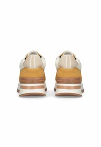 Baskets avec une tige crème et jaune, design élégant, panneaux texturés et semelle intermédiaire blanche avec des rayures brunes ; détail de marque à l'arrière.