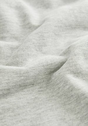 Tessuto grigio chiaro con una trama texturizzata e un motivo a maglia morbido, caratterizzato da sottili variazioni di tonalità e un aspetto morbido e flessibile.