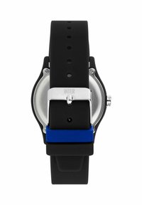 Cinturino in silicone nero con cassa in acciaio inox argentato, caratterizzato da un accento blu vicino alla fibbia; design minimalista con forma circolare.