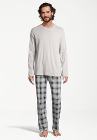 Haut à manches longues gris clair associé à un pantalon de pyjama à carreaux bleu et gris, en tissu doux. Présente une coupe décontractée et un design à jambe droite.